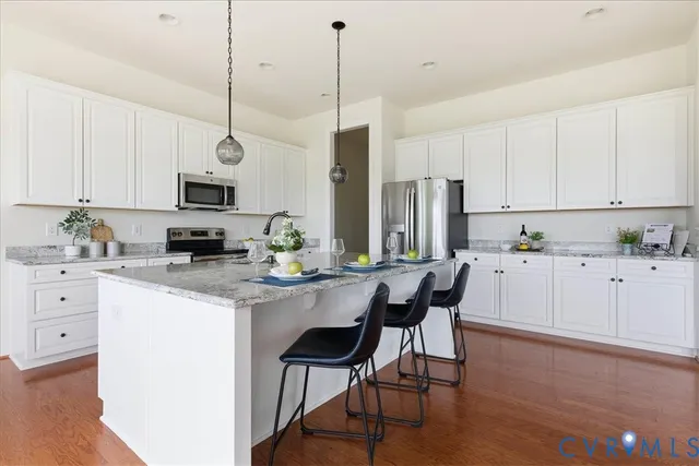 a dining room with furniture potted plants and wooden floor