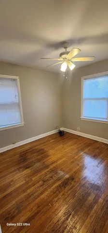 a view of a room with wooden floor and fan