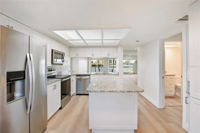 a kitchen with granite countertop a sink stove and refrigerator
