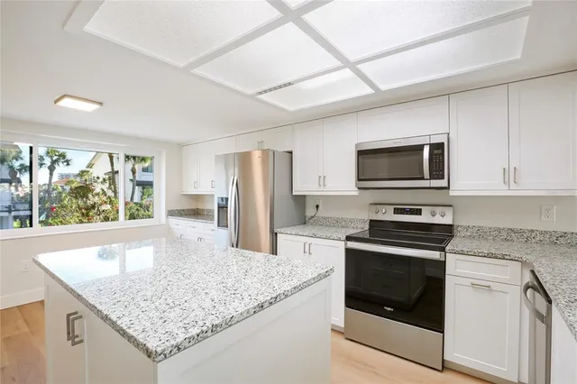 a kitchen with stainless steel appliances granite countertop a sink a stove and a refrigerator