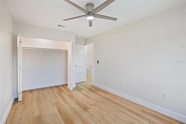 an empty room with a window and wooden floor