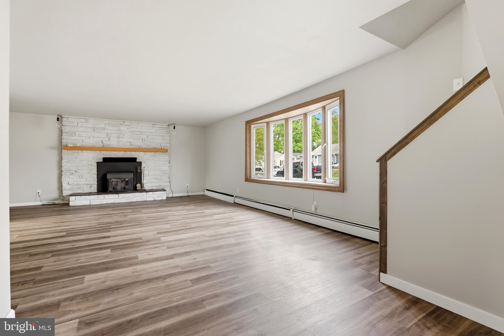 1816 Keymar Road Edgewater, MD 21037 - Photo 13 of 42 an empty room with wooden floor fireplace and windows