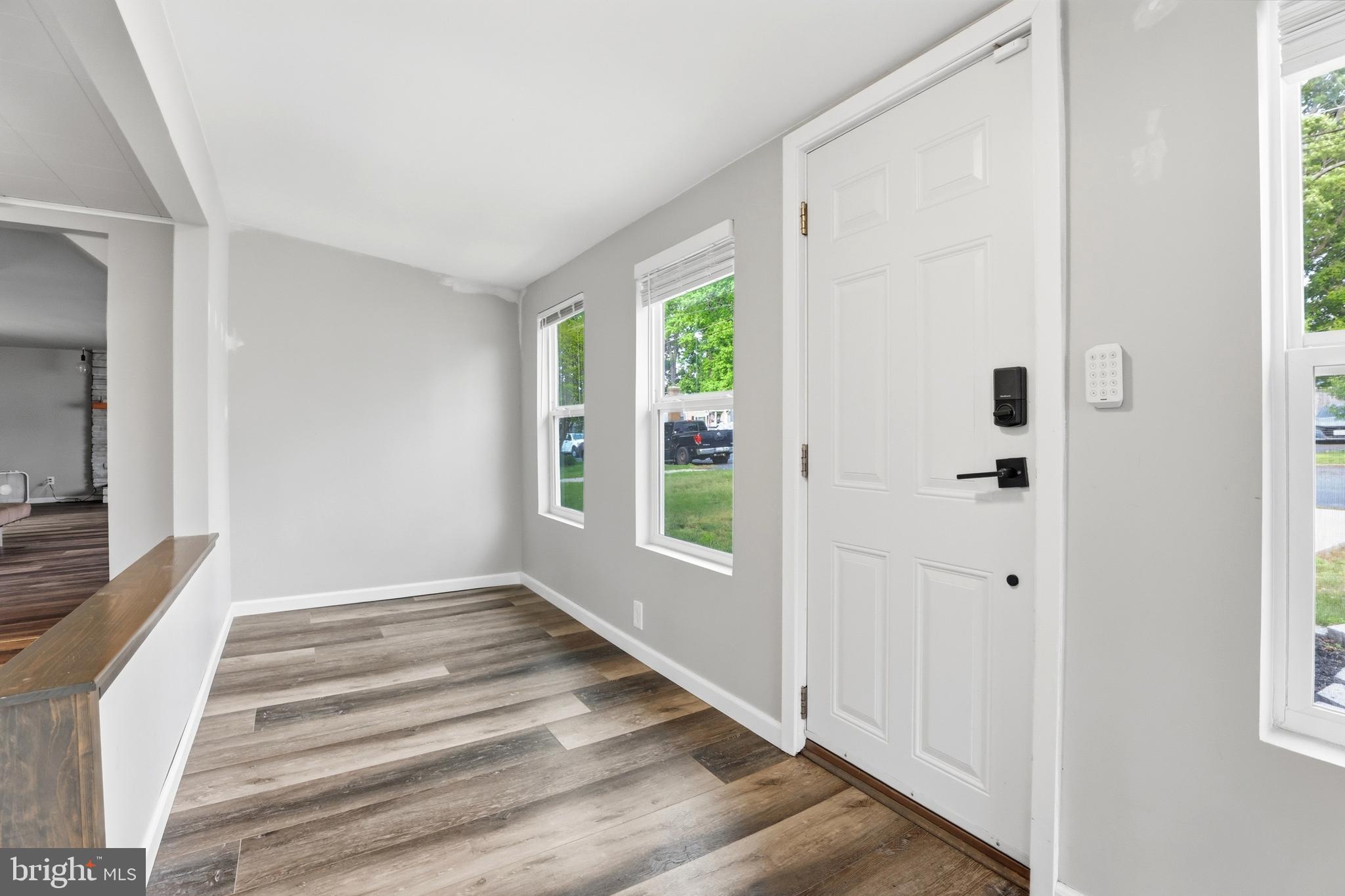 1816 Keymar Road Edgewater, MD 21037 - Photo 3 of 42 a view of an entryway with wooden floor leading to a furnished livingroom and windows