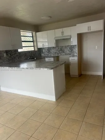 a kitchen with stainless steel appliances a sink a stove a microwave and a refrigerator