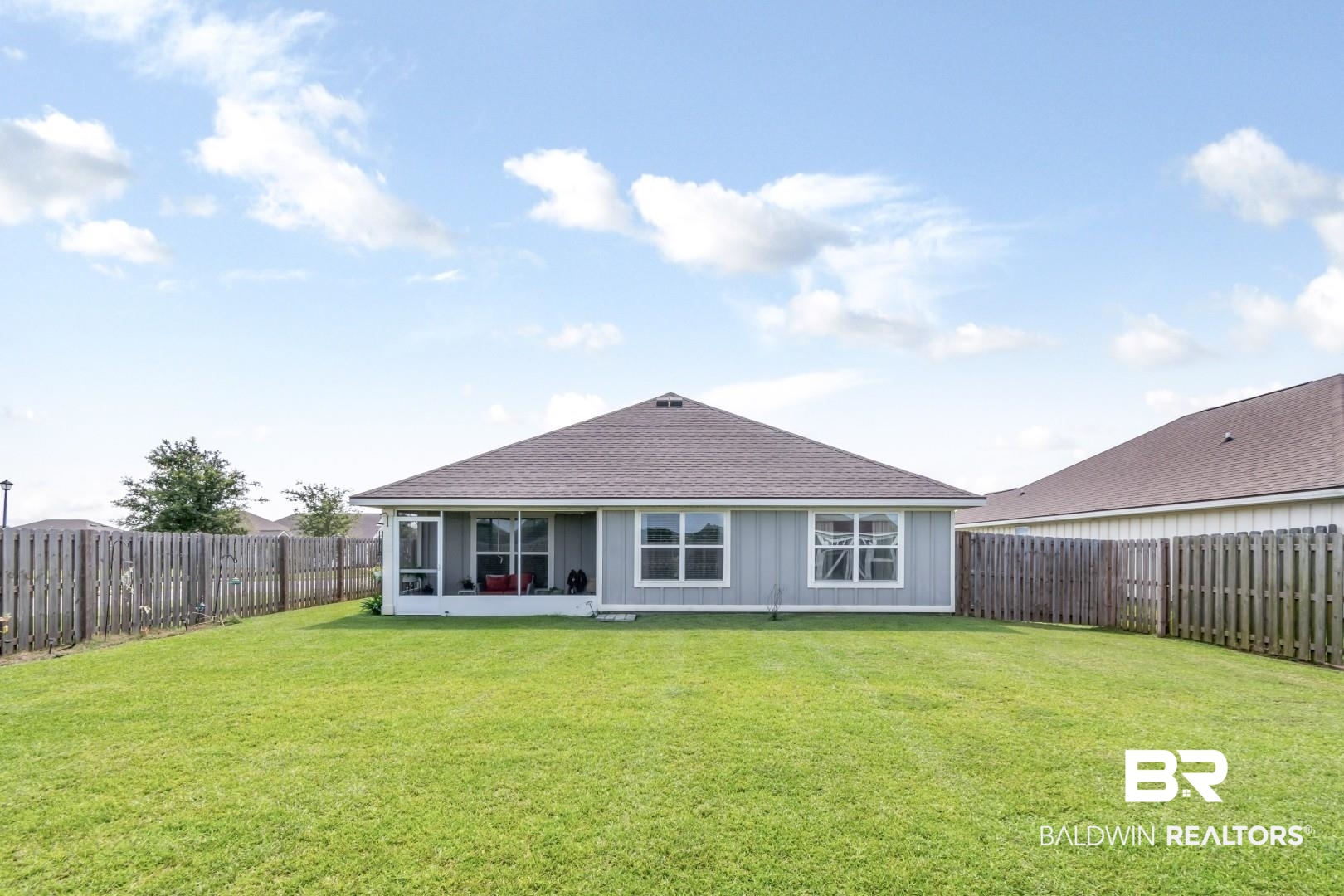 1295 Hayward Loop Foley, AL 36535 - Photo 25 of 29 Expansive fenced backyard featuring a manicured lawn and a screened-in porch with multiple windows