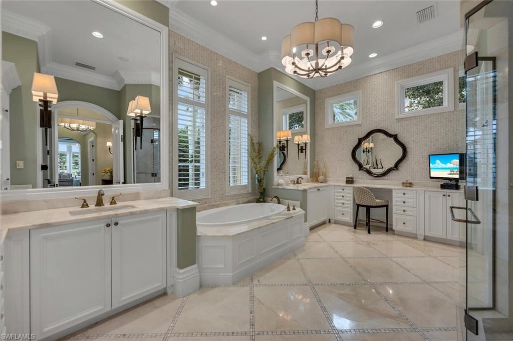 2125 Canna Way Naples, FL 34105 - Photo 21 of 43 Full bathroom with a chandelier, inlaid floor details, two vanities, a bath, and crown molding