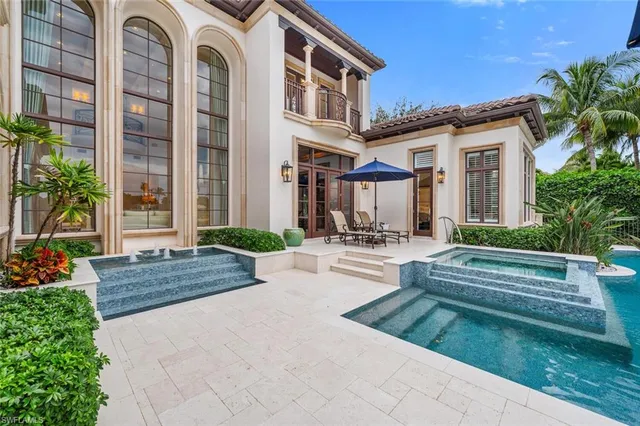 a front view of a house with swimming pool having outdoor seating