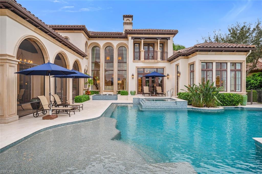 2125 Canna Way Naples, FL 34105 - Photo 42 of 43 Rear view of house with stucco siding, a patio area, a pool with connected hot tub, a balcony, and a chimney