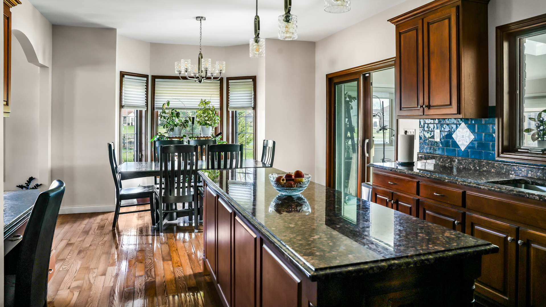 1607 Chestnut Grove Court Champaign, IL 61822 - Photo 34 of 113 a kitchen with stainless steel appliances granite countertop a stove top oven a dining table and chairs with wooden floor