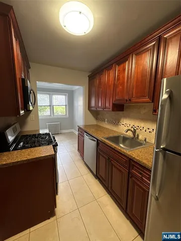 a kitchen with stainless steel appliances granite countertop a stove sink and refrigerator