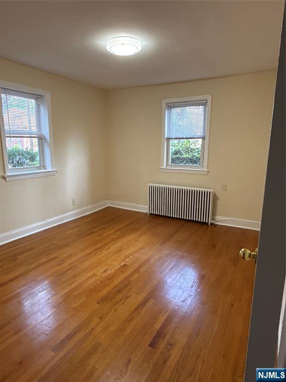 166 Grand Avenue, Unit A7 Englewood, NJ 07631 - Photo 8 of 12 an empty room with wooden floor and windows