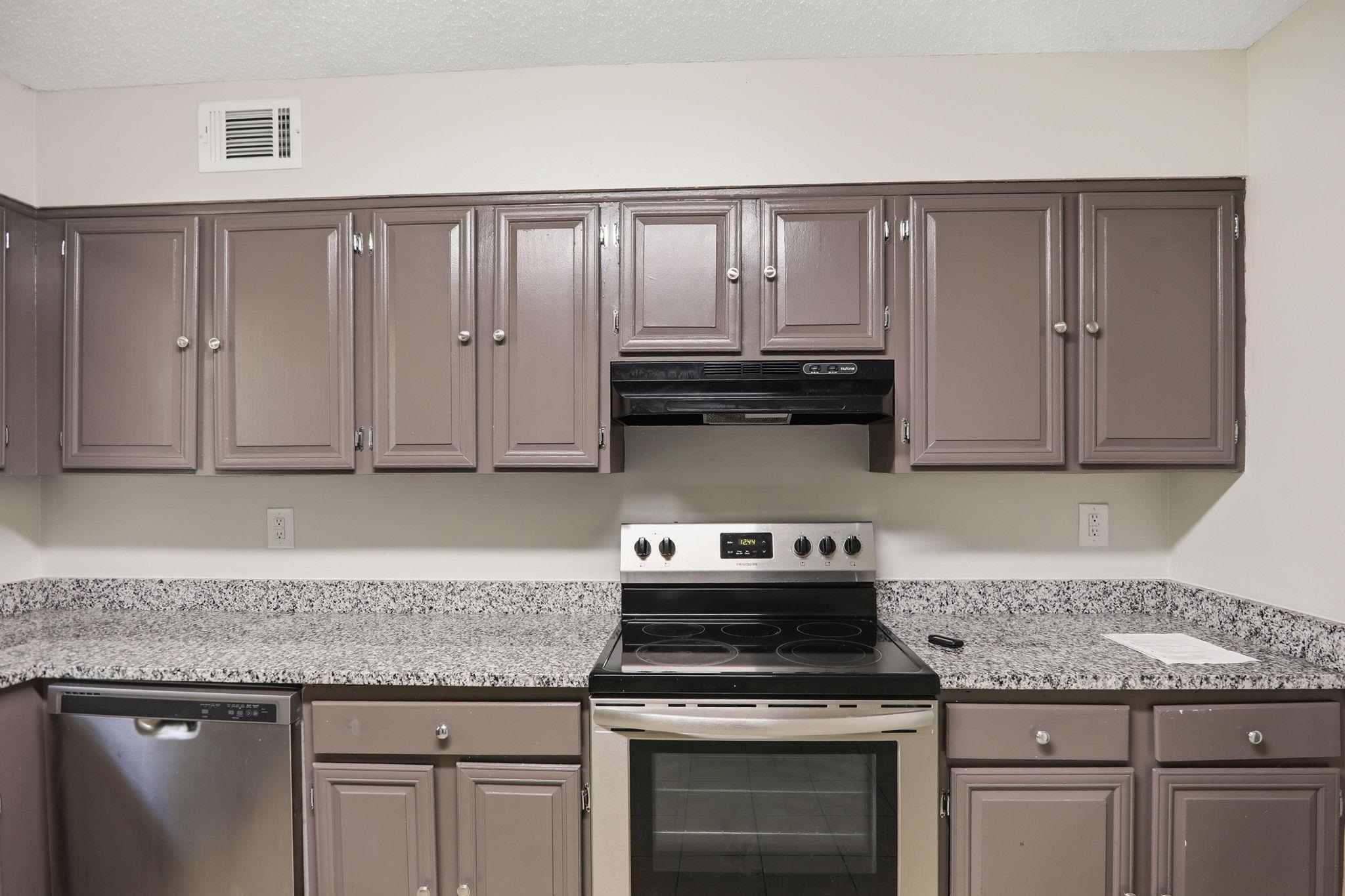 3113 Raleigh Ridge Cove Memphis, TN 38128 - Photo 13 of 38 Kitchen featuring painted cabinetry, granite-finish countertops, and a stainless steel oven/range and dishwasher