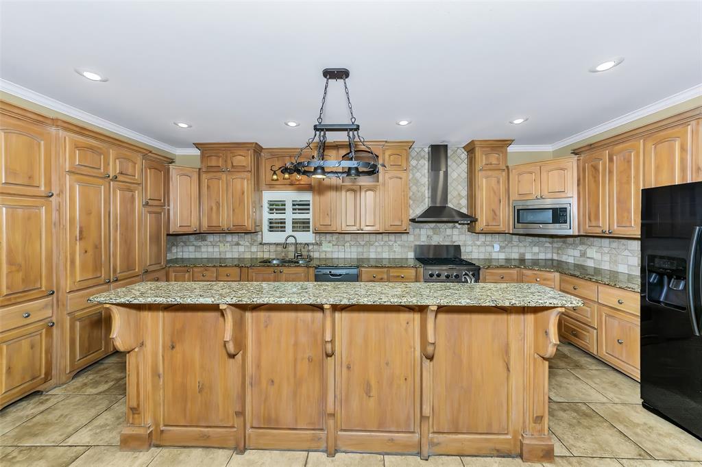 566 Selma Park Road Bowie, TX 76230 - Photo 9 of 40 Kitchen featuring a central island with a granite countertop, extensive light wood cabinetry, recessed lighting, and a stainless steel range hood