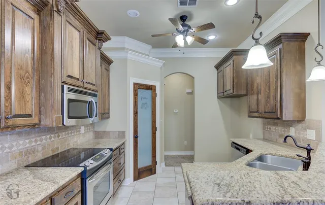 a kitchen with granite countertop a sink stainless steel appliances and cabinets