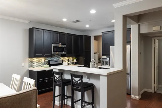 a kitchen with granite countertop wooden cabinets and stainless steel appliances