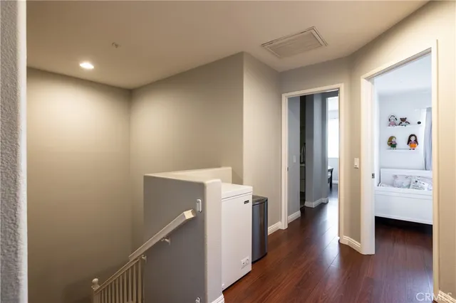a view of a hallway with wooden floor and furniture
