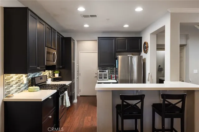 a kitchen with stainless steel appliances a sink stove refrigerator and cabinets