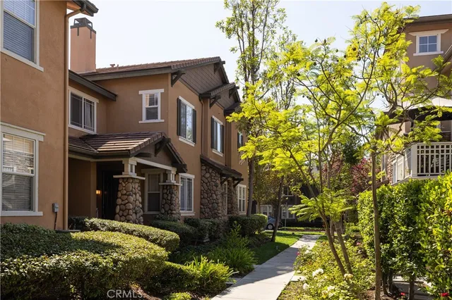 a view of a brick house with a yard and plants