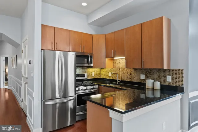 a kitchen with a refrigerator sink and cabinets