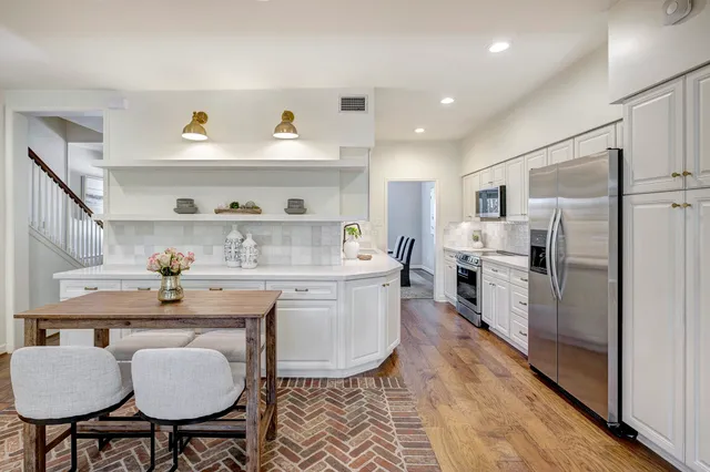 a kitchen with refrigerator and chairs