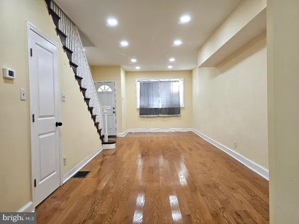a view of empty room with wooden floor