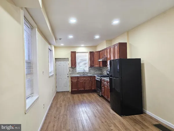 a kitchen with wooden floor and a refrigerator