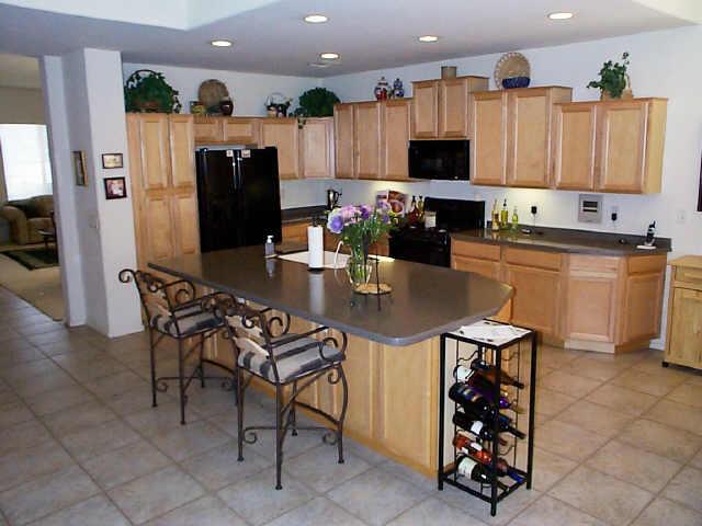 495 East Ranch Road Gilbert, AZ 85296 - Photo 3 of 6 a kitchen with stainless steel appliances kitchen island granite countertop a refrigerator and a stove top oven
