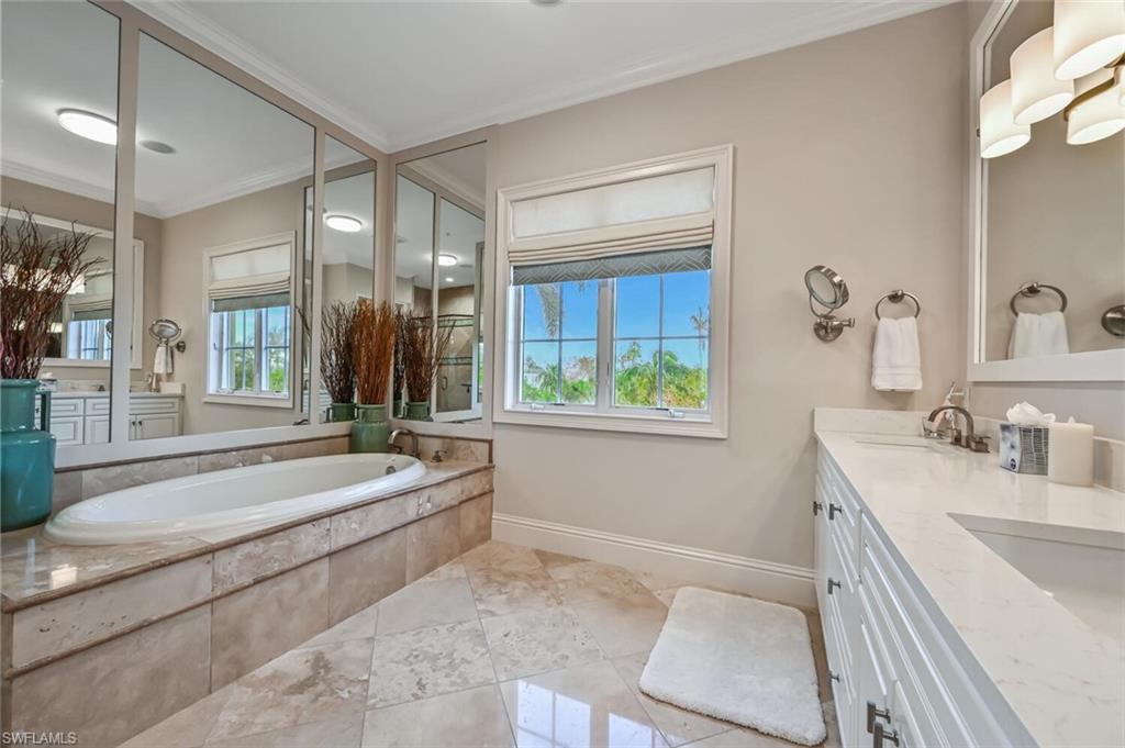 425 5th Street South, Unit A Naples, FL 34102 - Photo 25 of 44 a spacious bathroom with a tub sink and mirror