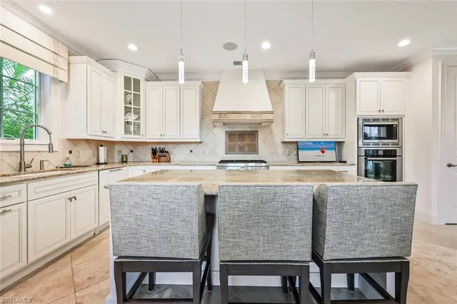 a kitchen with a table chairs sink microwave and cabinets