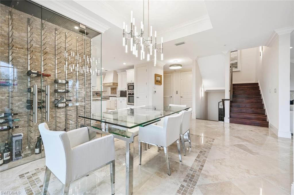 425 5th Street South, Unit A Naples, FL 34102 - Photo 8 of 44 a dining room with furniture and a chandelier