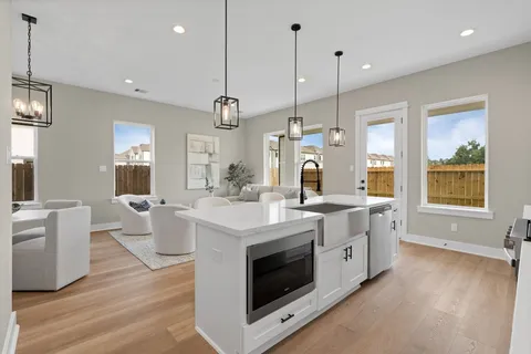 a kitchen with a sink a stove and chairs