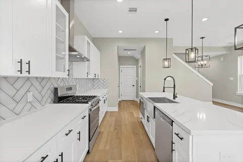 a kitchen with kitchen island granite countertop a sink a center island and cabinets