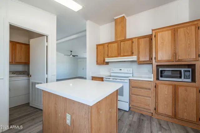 a kitchen with a sink a stove cabinets and wooden floor
