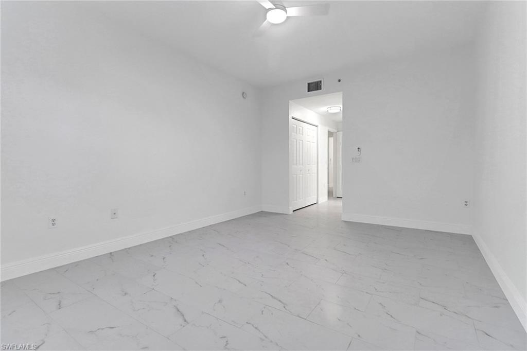 20170 Estero Gardens Circle, Unit 107 Estero, FL 33928 - Photo 18 of 44 an empty room with a ceiling fan and window