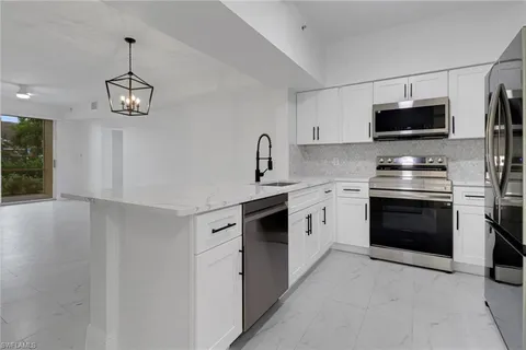 a kitchen with stainless steel appliances a stove a microwave and a sink