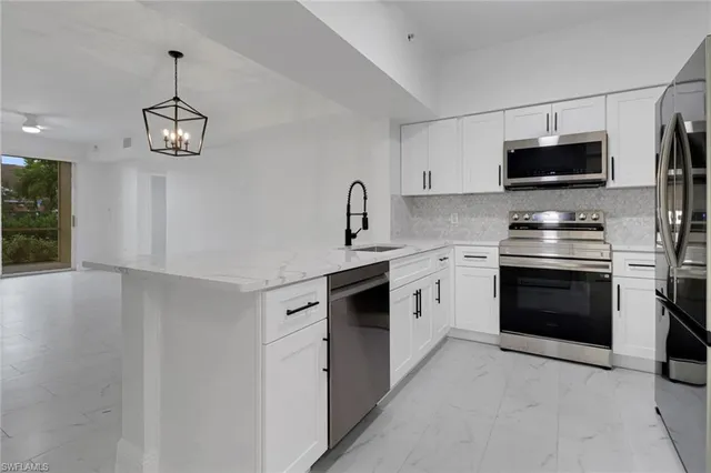 a kitchen with stainless steel appliances a stove a microwave and a sink