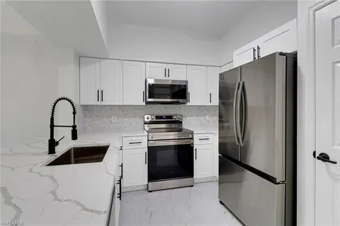 a kitchen with stainless steel appliances a refrigerator stove and microwave