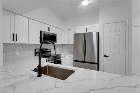 a kitchen with a refrigerator and a stove top oven