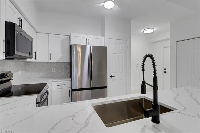 a kitchen with a sink a counter top space cabinets and stainless steel appliances