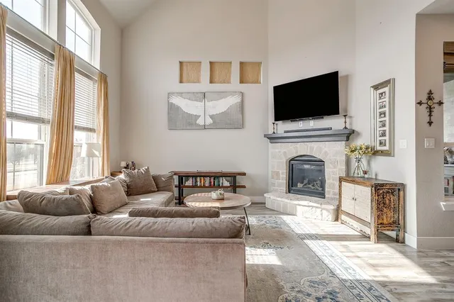 a living room with furniture a flat screen tv and a fireplace
