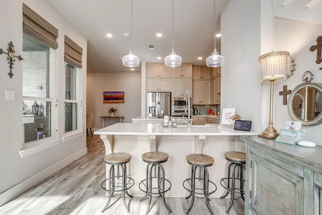 a kitchen with kitchen island stainless steel appliances a dining table and chairs