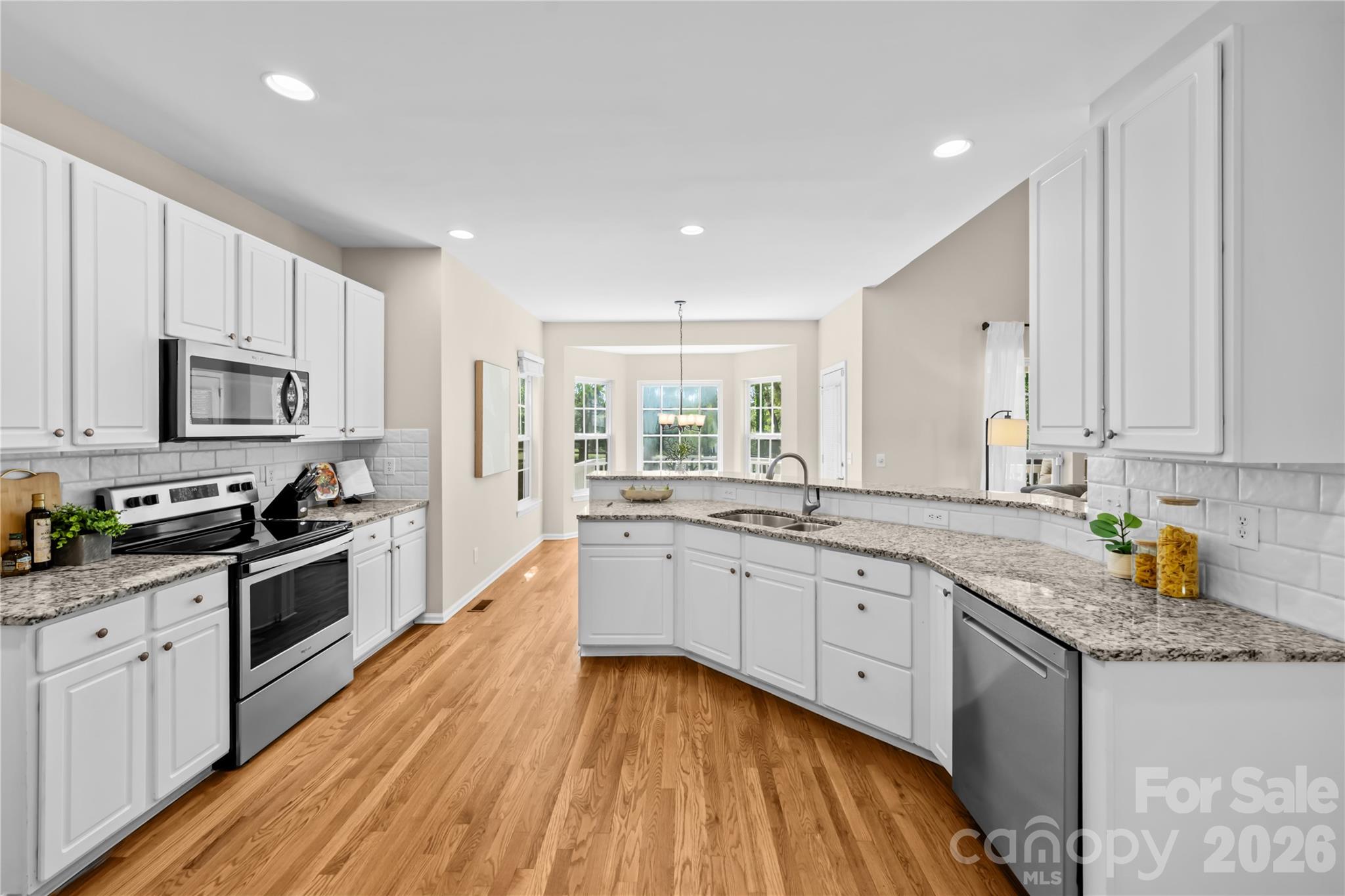 13338 Fremington Road Huntersville, NC 28078 - Photo 11 of 34 a kitchen with granite countertop white cabinets sink and stainless steel appliances