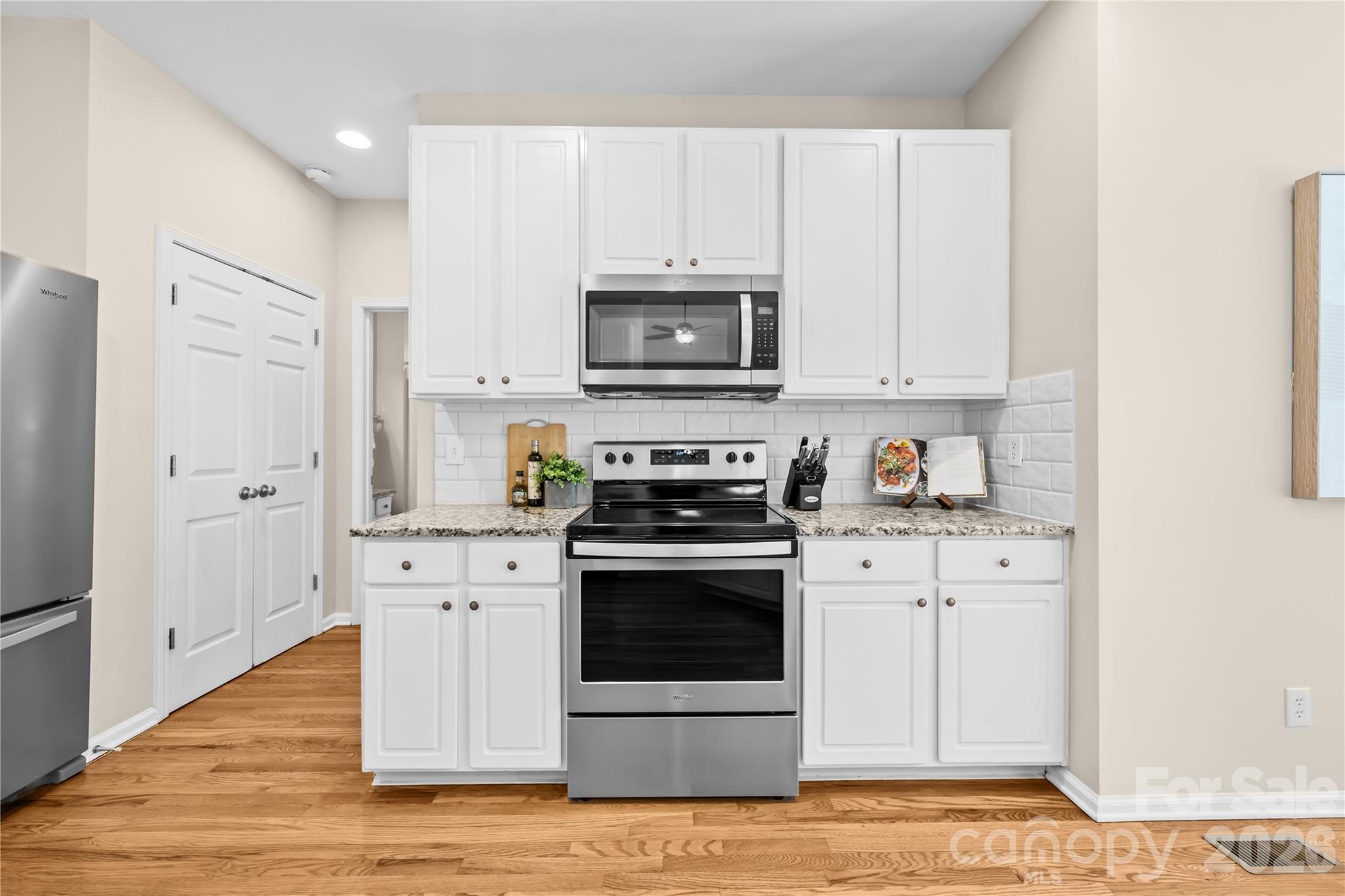13338 Fremington Road Huntersville, NC 28078 - Photo 13 of 34 a kitchen with stainless steel appliances granite countertop a stove a white refrigerator a sink and white cabinets
