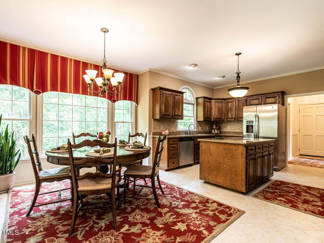 5317 Deep Valley Raleigh, NC 27606 - Photo 24 of 59 a kitchen with stainless steel appliances granite countertop a stove top oven a sink a dining table and chairs with wooden floor