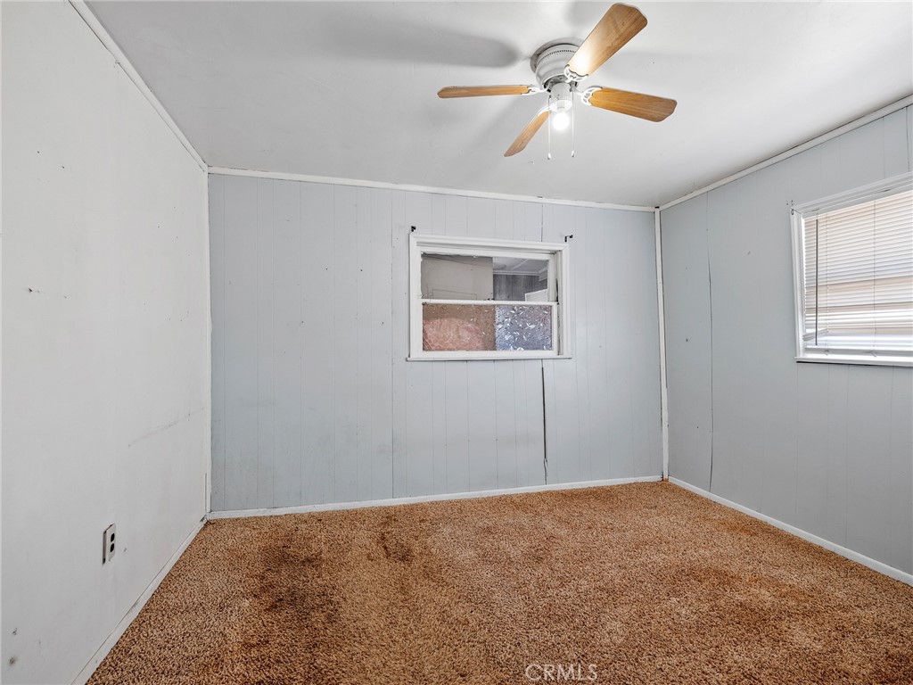19876 Stoddard Wells Road Apple Valley, CA 92307 - Photo 17 of 40 a view of a room with a ceiling fan and a window