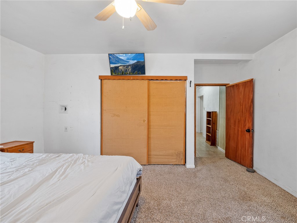 19876 Stoddard Wells Road Apple Valley, CA 92307 - Photo 20 of 40 a bedroom with a bed and a chandelier