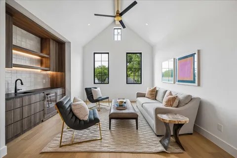 a living room with furniture two window and wooden floor