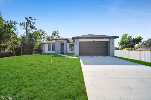 a front view of a house with yard and a garage