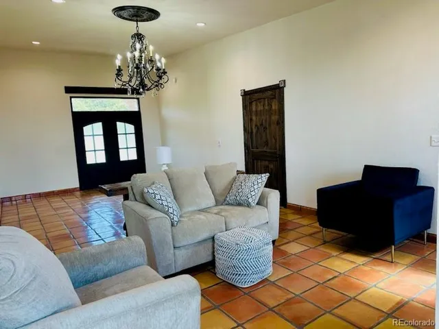 a living room with furniture and a chandelier