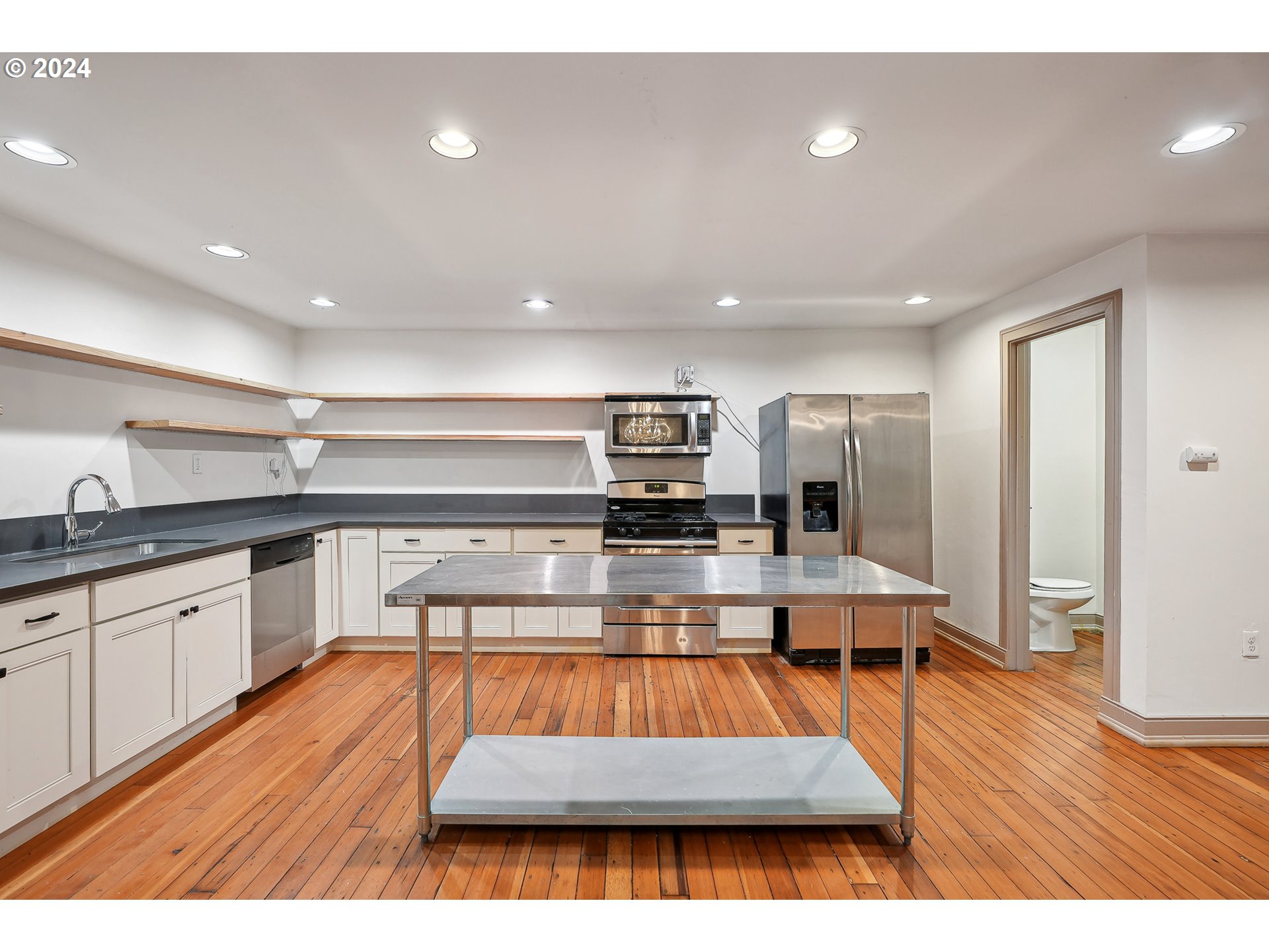 3903 North Michigan Avenue Portland, OR 97227 - Photo 17 of 47 a kitchen with stainless steel appliances granite countertop a refrigerator a sink dishwasher and wooden cabinets with wooden floor